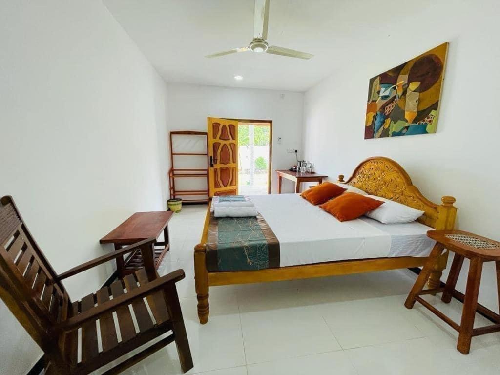Schlafzimmer mit einem Bett, einem Tisch und Stühlen in der Unterkunft Jaffna Palmyrah Hotel in Jaffna