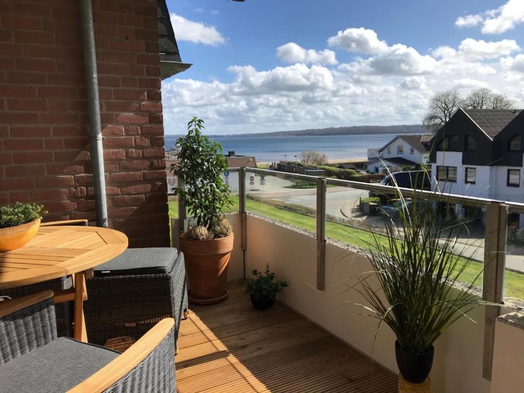 a balcony with a table and a view of the water at fewo1846 - Promenade Wassersleben in Harrislee