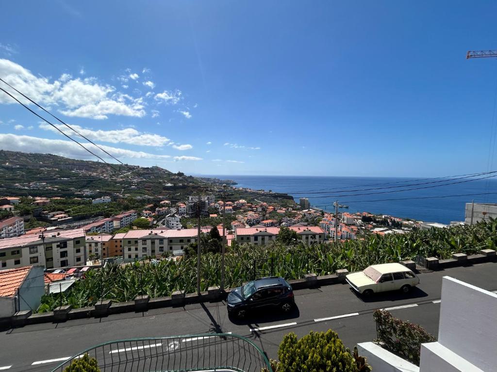 una vista de una ciudad con coches aparcados en un aparcamiento en Vila Pico da Torre Apartment, en Câmara de Lobos