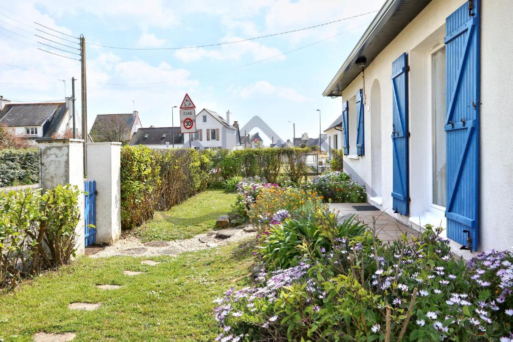 a street in a village with houses and flowers at LocaLise - M3B - Souvenir du Guil - Maison de plain-pied avec jardin clos au Guilvinec - Tout à pied, plages, port, centre, commerces, marché - Wif inclus - Linge de lit inclus - Animaux bienvenus in Le Guilvinec