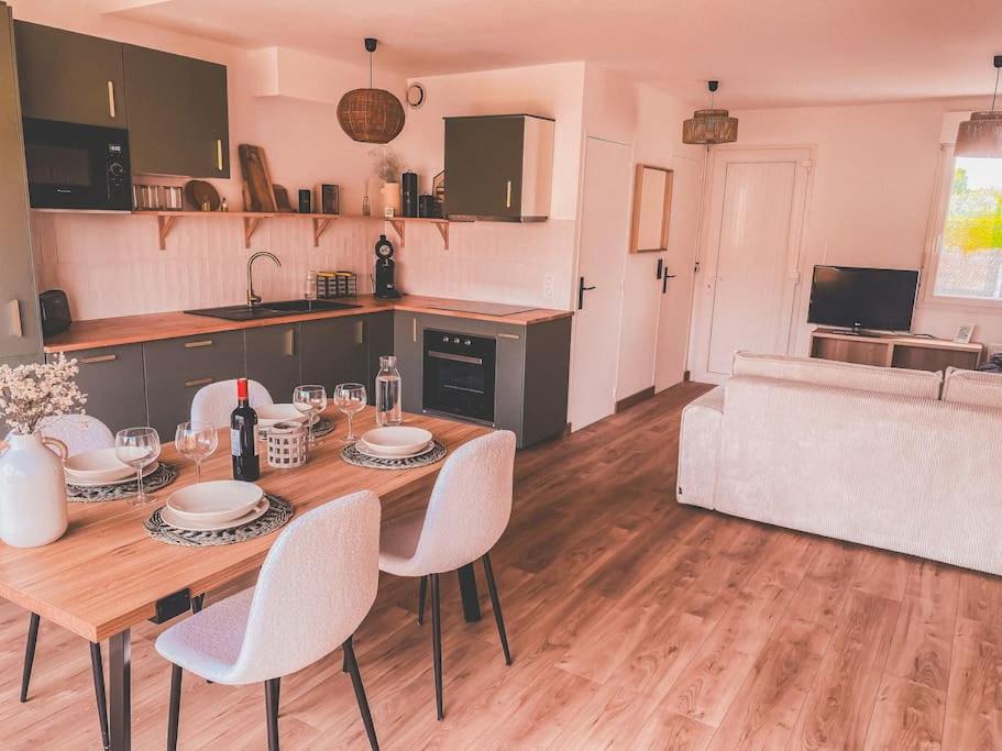 une cuisine avec une table et des chaises dans une pièce dans l'établissement Maison familiale proche de la mer, à Saint-Palais-sur-Mer