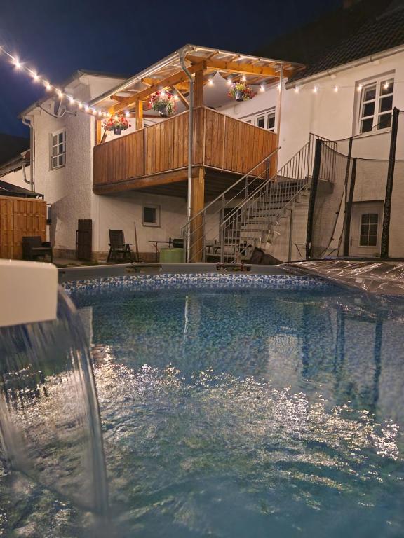 uma piscina em frente a uma casa com luzes em Ferienhaus del Pueblo 