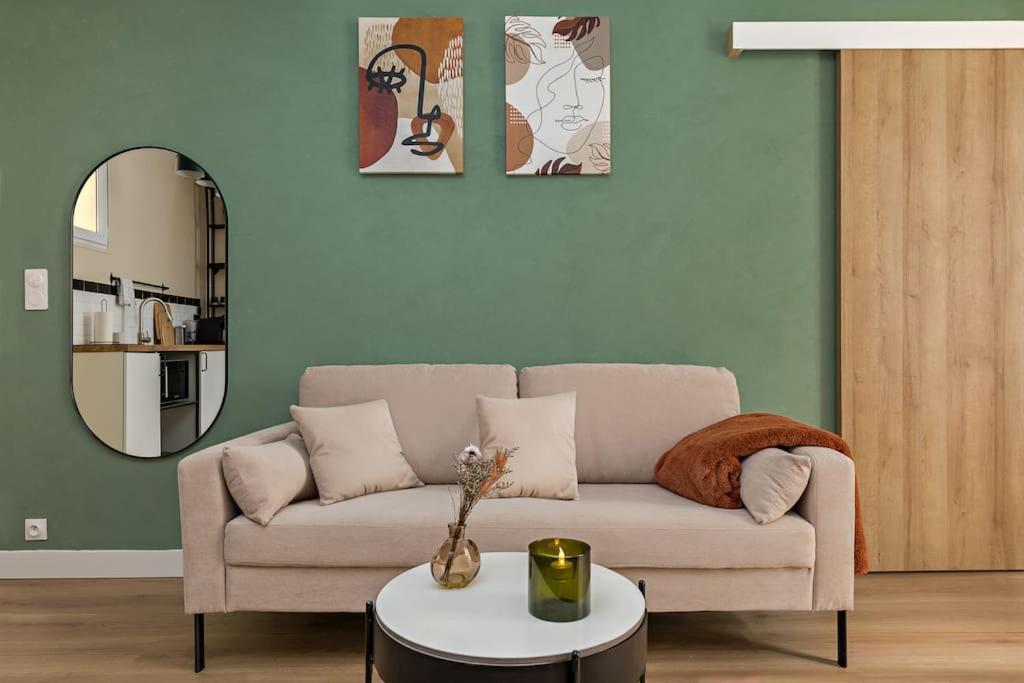 een woonkamer met een bank en een tafel bij Appartement 2P Confort Hyper Centre & 100m de la plage in Dieppe