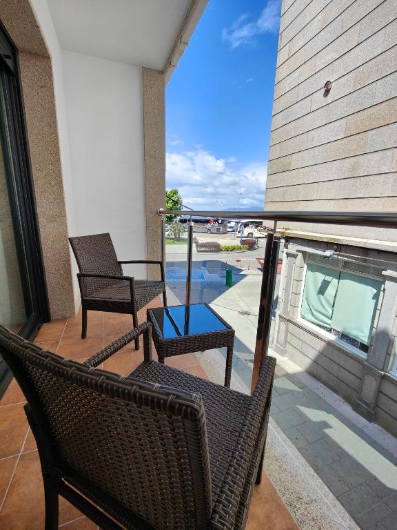 a patio with two chairs and a table on a balcony at Casa Marga O Grove in O Grove