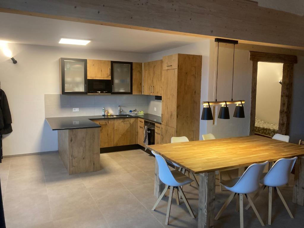 una cucina con tavolo in legno e sedie blu di Le Fort a Gimel