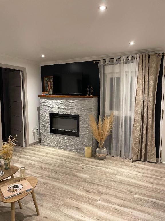 Il comprend un salon doté d'une cheminée et d'une télévision à écran plat. dans l'établissement Maison avec cheminée et jardin près des commerces, à Béziers