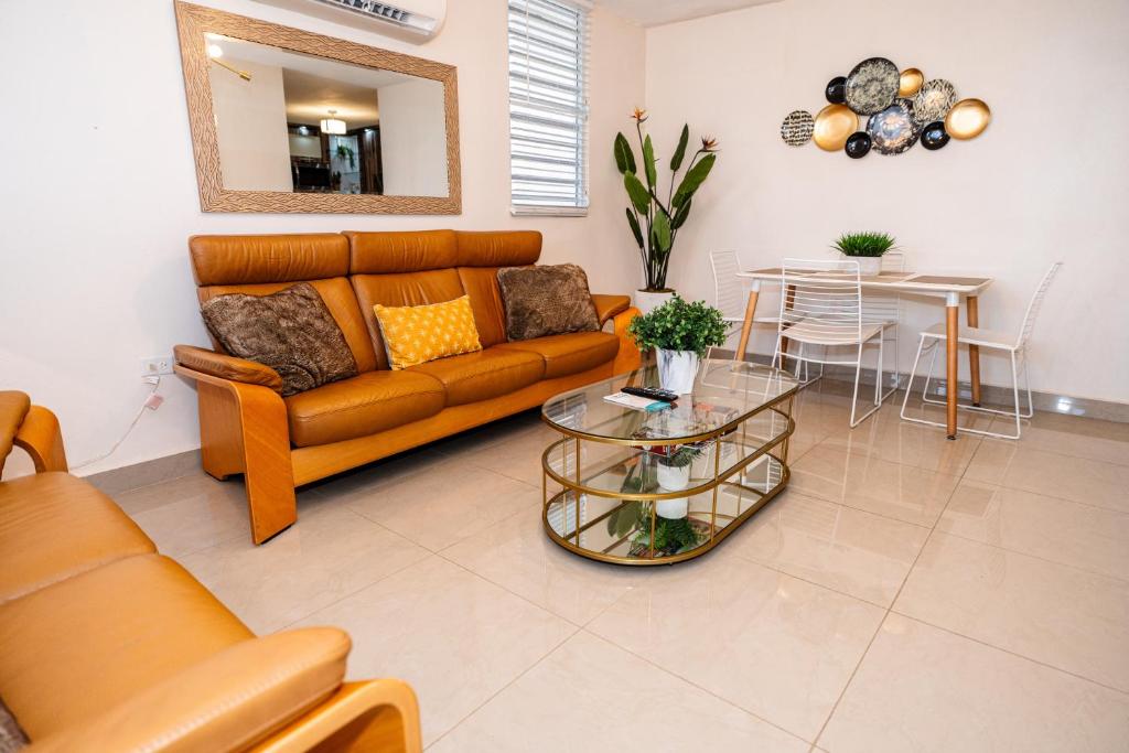 un soggiorno con divano e tavolo di Spacious Retreat with Private Jacuzzi and Terrace a Ponce