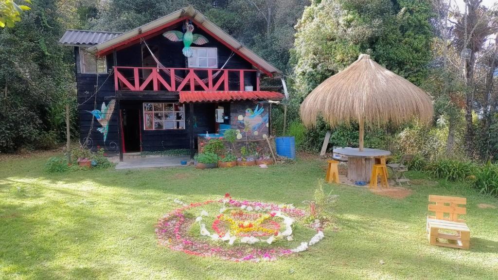 una pequeña casa con un jardín de flores delante de ella en Cabaña Colibri naturaleza vista Laguna de la Cocha, en Pasto