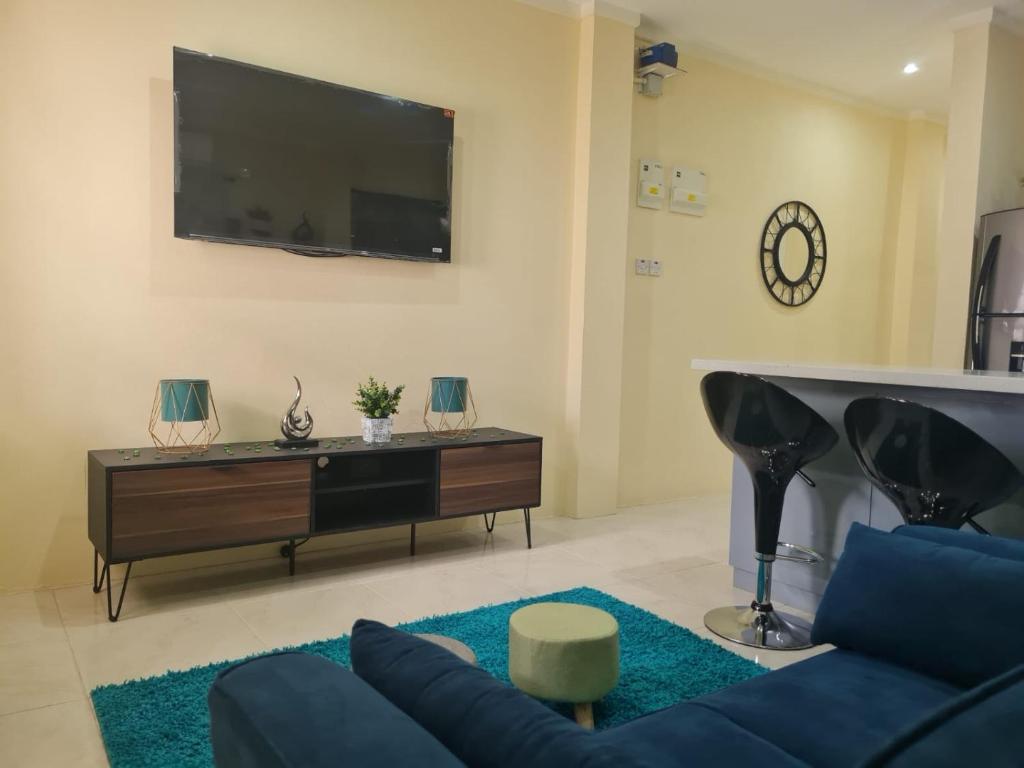 un soggiorno con un divano blu e una TV di Rivière Chateau - Gros Islet a Gros Islet