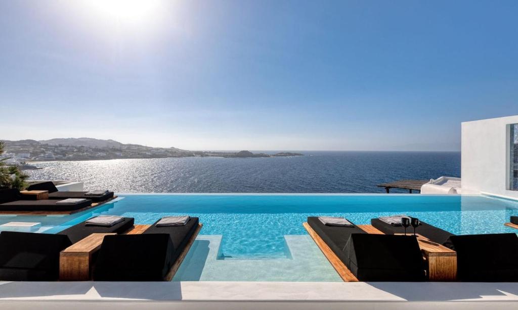 ein Swimmingpool mit Blick auf das Meer in der Unterkunft Mbc Psarou Black Retreat 11 Bedrooms Mykonos in Psarrou