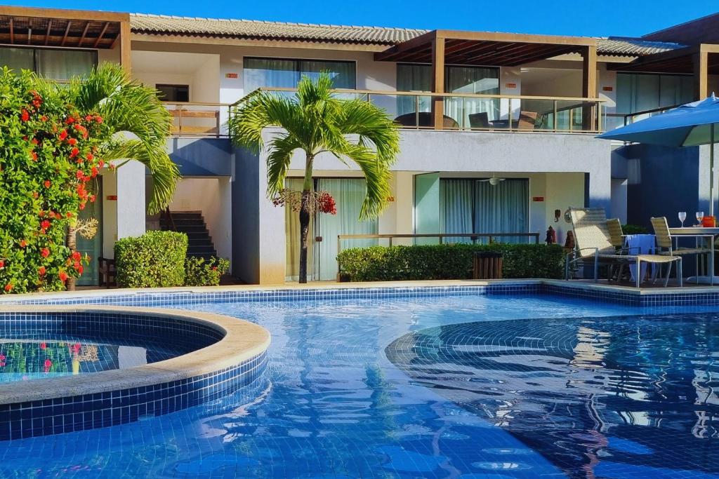 a swimming pool in front of a building at Solaris 6 - duplex 2 quartos 10 mn a pé da praia in Imbassai