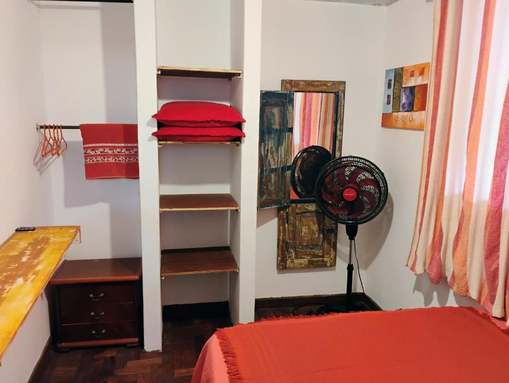 a room with a bedroom with a bed and a fan at Pousada Seu Souza in Belo Horizonte