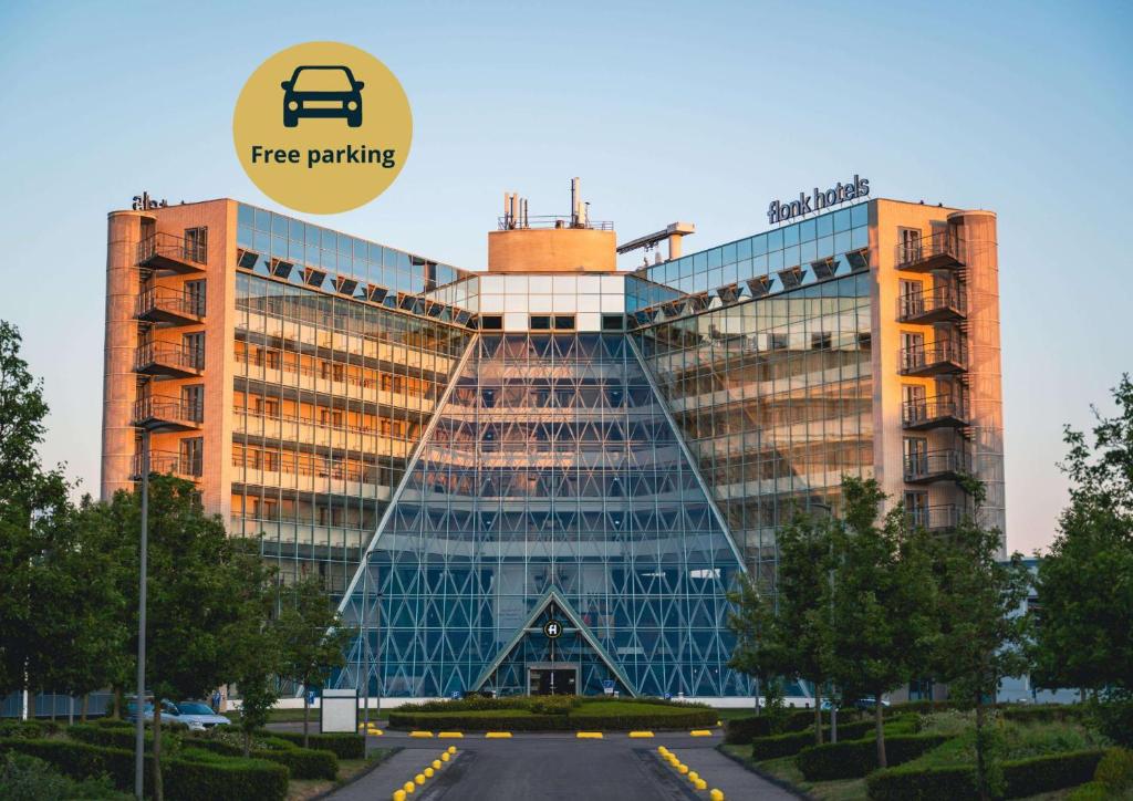 a building with the free parking sign on it at Flonk Hotel Groningen Zuid, BW Signature Collection in Groningen