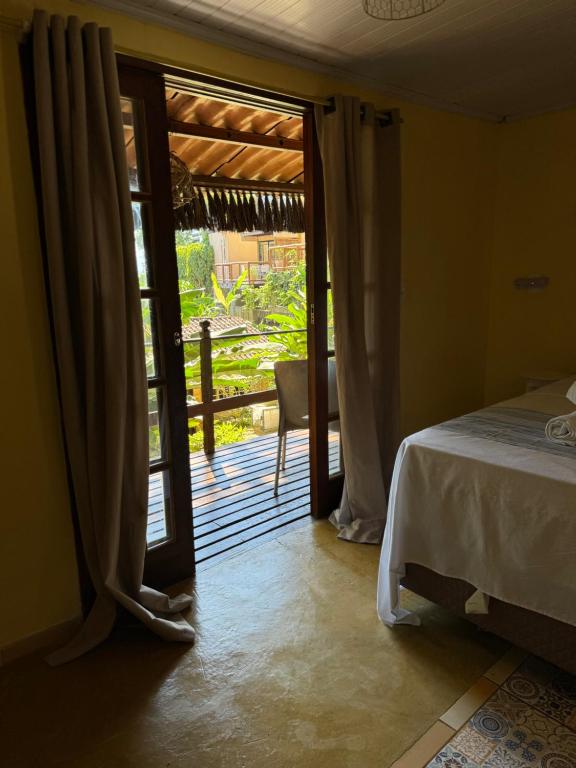 um quarto com uma cama e uma porta de vidro deslizante em Chalé Maria Bonita - Ilha Grande, RJ em Angra dos Reis