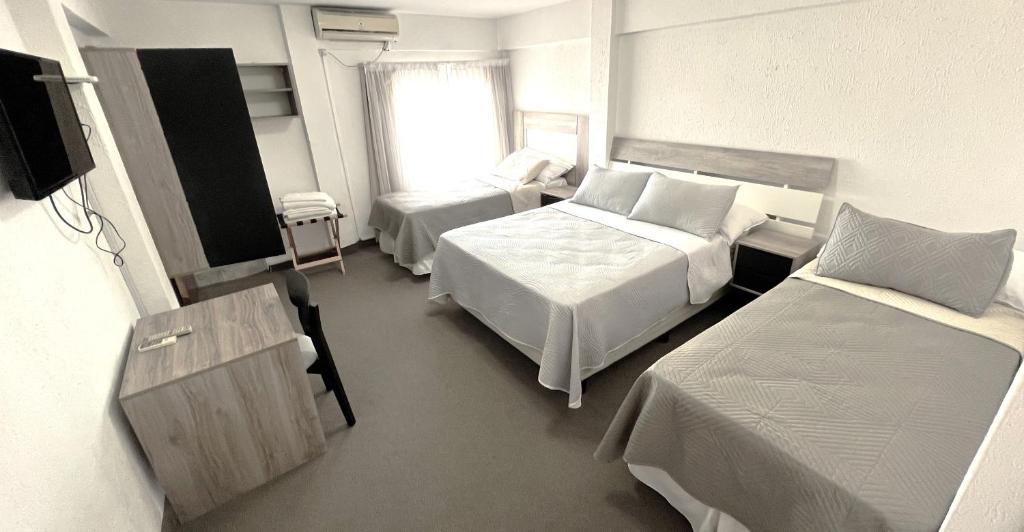 um quarto de hotel com duas camas e uma televisão em Hotel Plaza Formosa em Formosa