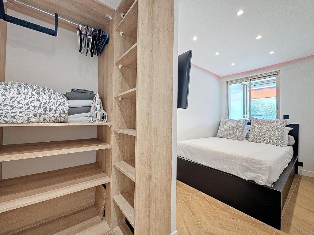 - une petite chambre avec un lit et un placard dans l'établissement 2 pièces 35 m2 + 1 véranda, à Antibes