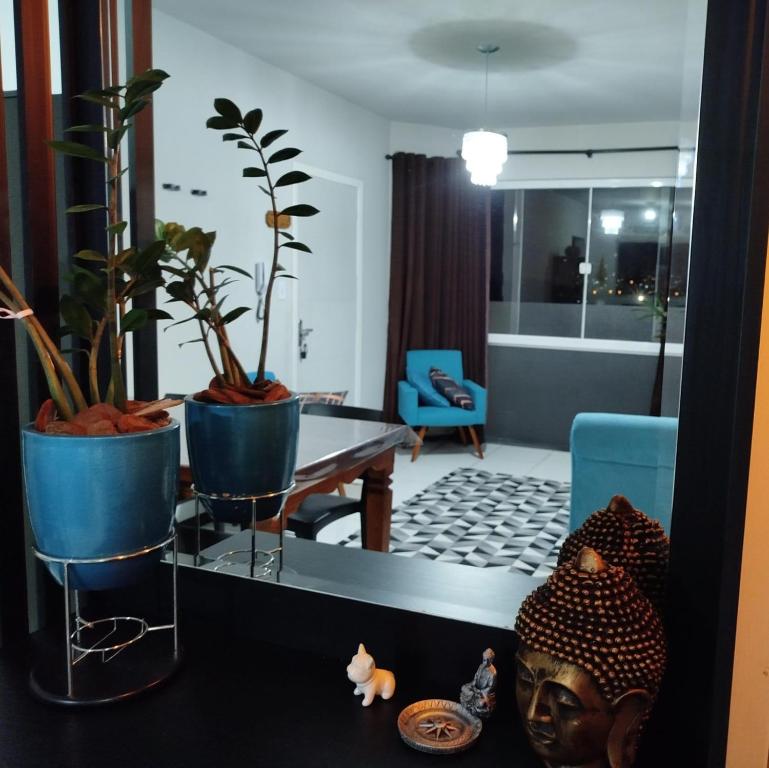 Una sala de estar con plantas en macetas y una mesa de cristal. en não disponível, en Itajaí