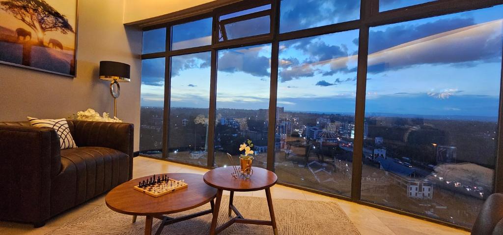 Una sala de estar con un sofá y una mesa y una ventana grande. en Serenity - Breathtaking Views, en Nairobi