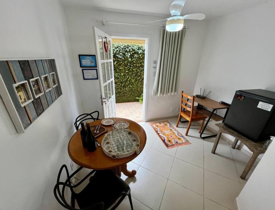 a living room with a table and a television at Suíte Girassol Cama & Café - Centro, Marechal Floriano-ES in Marechal Floriano