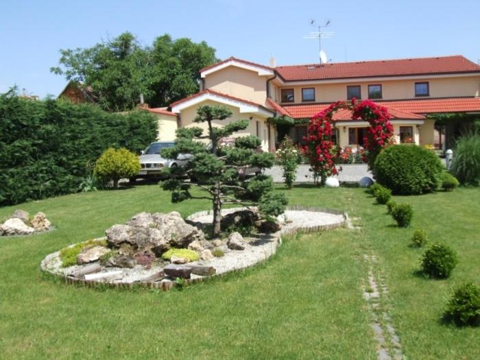 ein Haus mit einem Garten vor einem Haus in der Unterkunft Penzion 77 - Garni in Pezinok