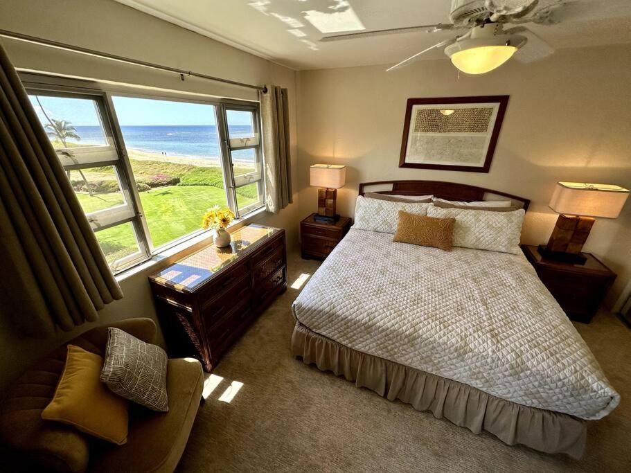 a bedroom with a bed and a large window at Beautiful Oceanfront, AC In Each Room, Sleeps 6 in Kihei