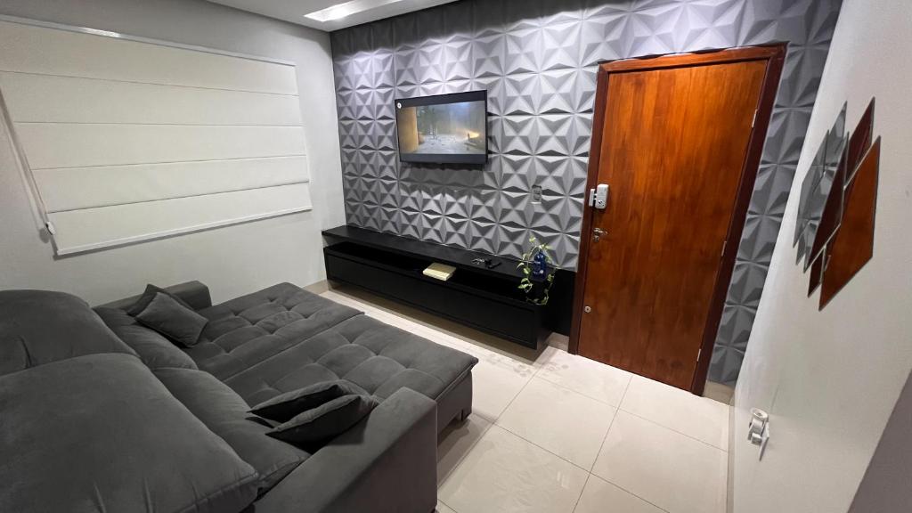 uma sala de estar com um sofá e uma televisão em Ap202 - Residencial Garves em Patos de Minas