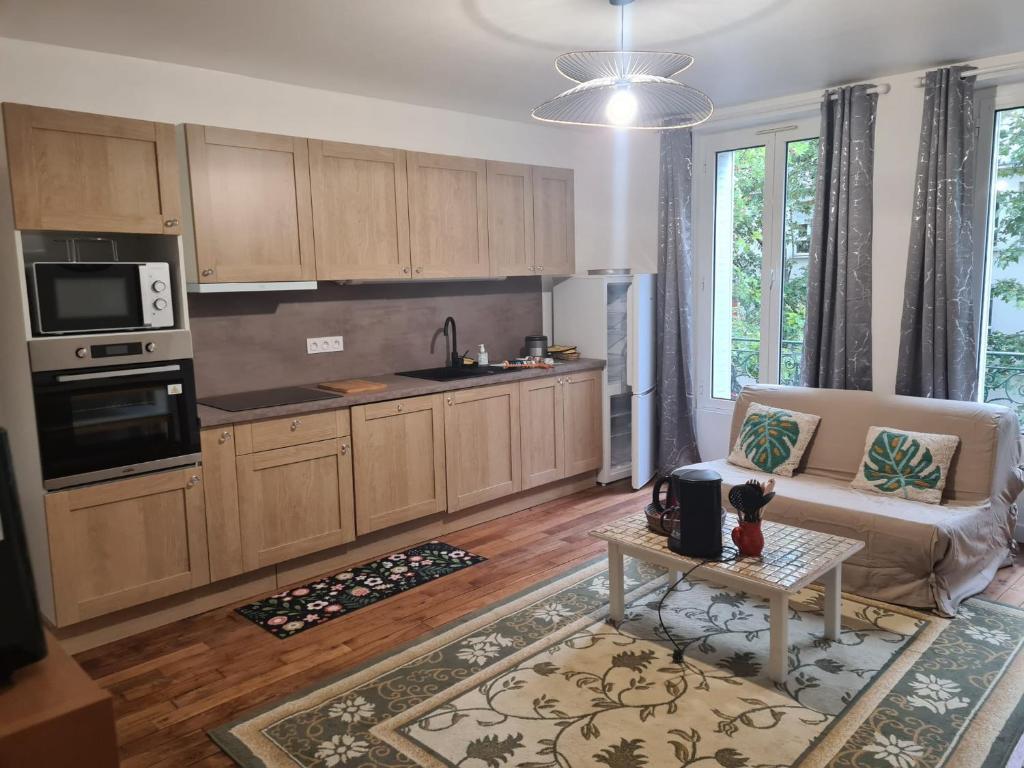 ein Wohnzimmer mit Couch und Küche in der Unterkunft Appartement saint ouen 45M2 in Saint-Ouen