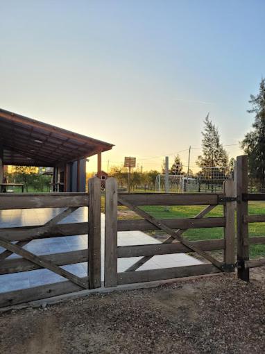 a wooden fence with a gate in front of a field at Ikigai in Concepción del Uruguay