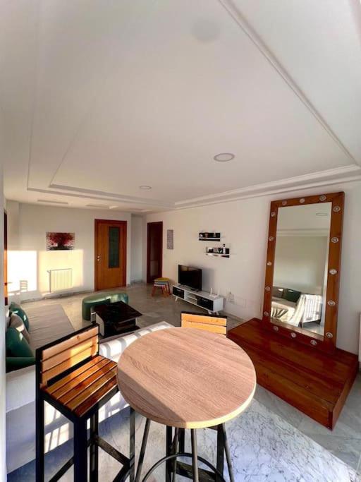 a living room with a wooden table and chairs at Superbe appartement salon deux grandes chambres à coucher in Al Karm