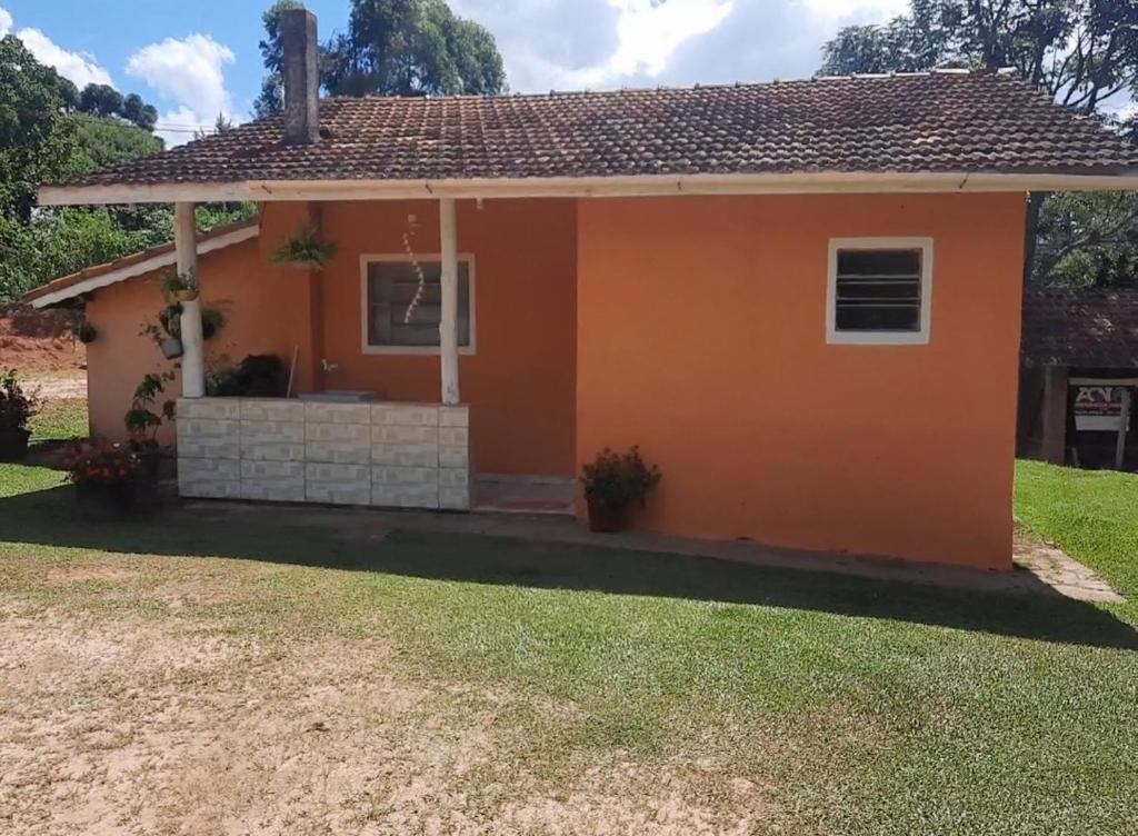 une petite maison avec une orange dans l'établissement Morada Jaguary, à Camanducaia