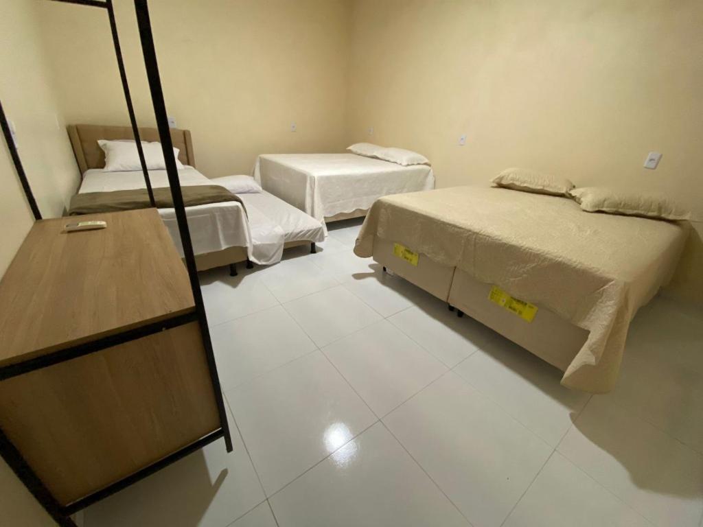 um quarto com duas camas e uma cómoda e um espelho em Condomínio Farol das Dunas em Santo Amaro