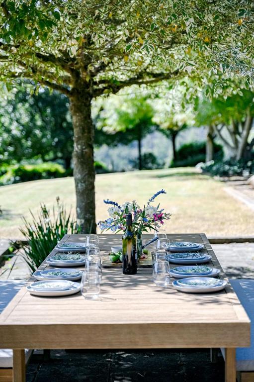 a wooden table with plates and glasses on it at The Old Dairy at Kangaloon in East Kangaloon