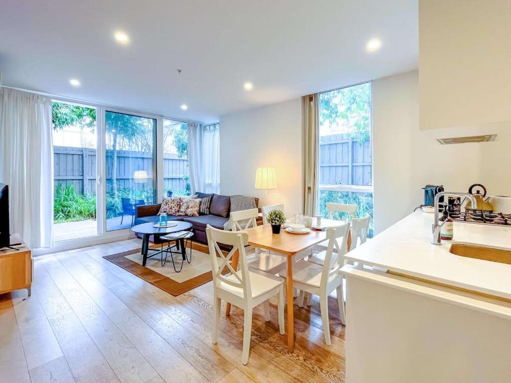 uma cozinha e sala de estar com mesa e cadeiras em BPM Brighton APT with Garden LG1 em Melbourne