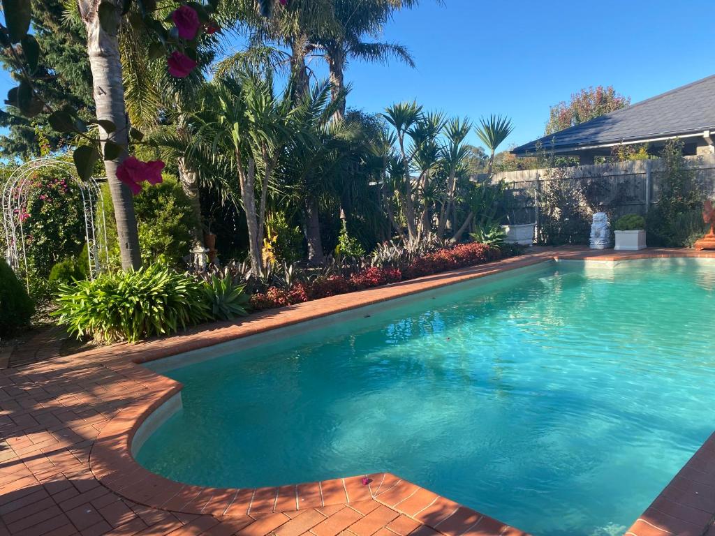 a swimming pool with blue water in a yard at Merrypetch in Safety Beach