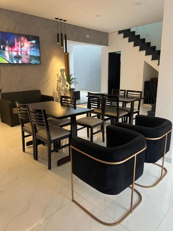 Hotel Pousada Colliseu في أباريسيدا: غرفة طعام مع كراسي وطاولة وتلفزيون