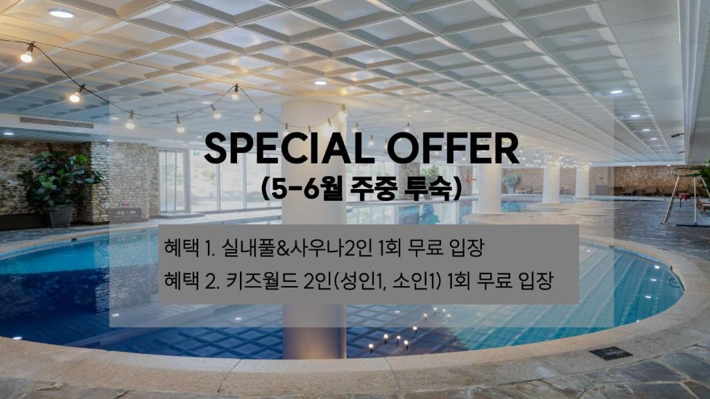 ein Pool in einem Gebäude mit einem speziellen Angebotsschild in der Unterkunft Kensington Hotel Pyeongchang in Pyeongchang