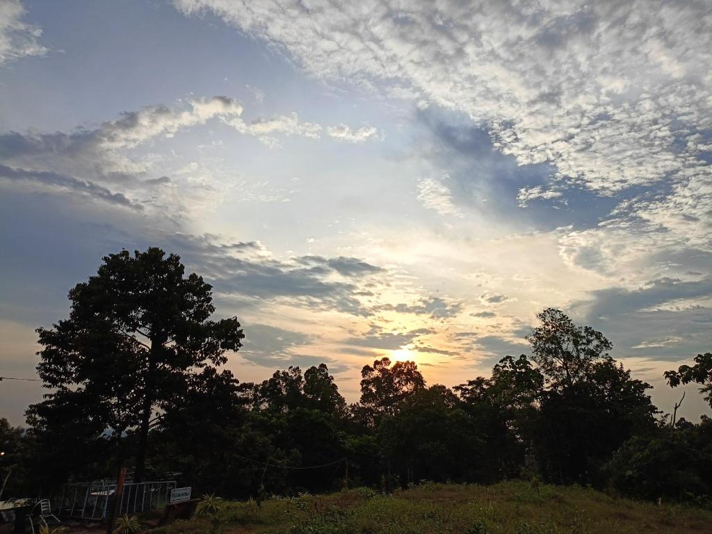 un cielo nuvoloso con alberi in un campo di BUKIT LIMAU REST HOUSE a Taiping