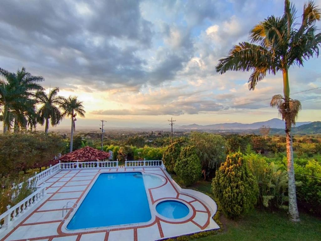 a swimming pool on top of a house with palm trees at Finca con hermosa vista, billar pool, piscina, atardeceres in Pereira