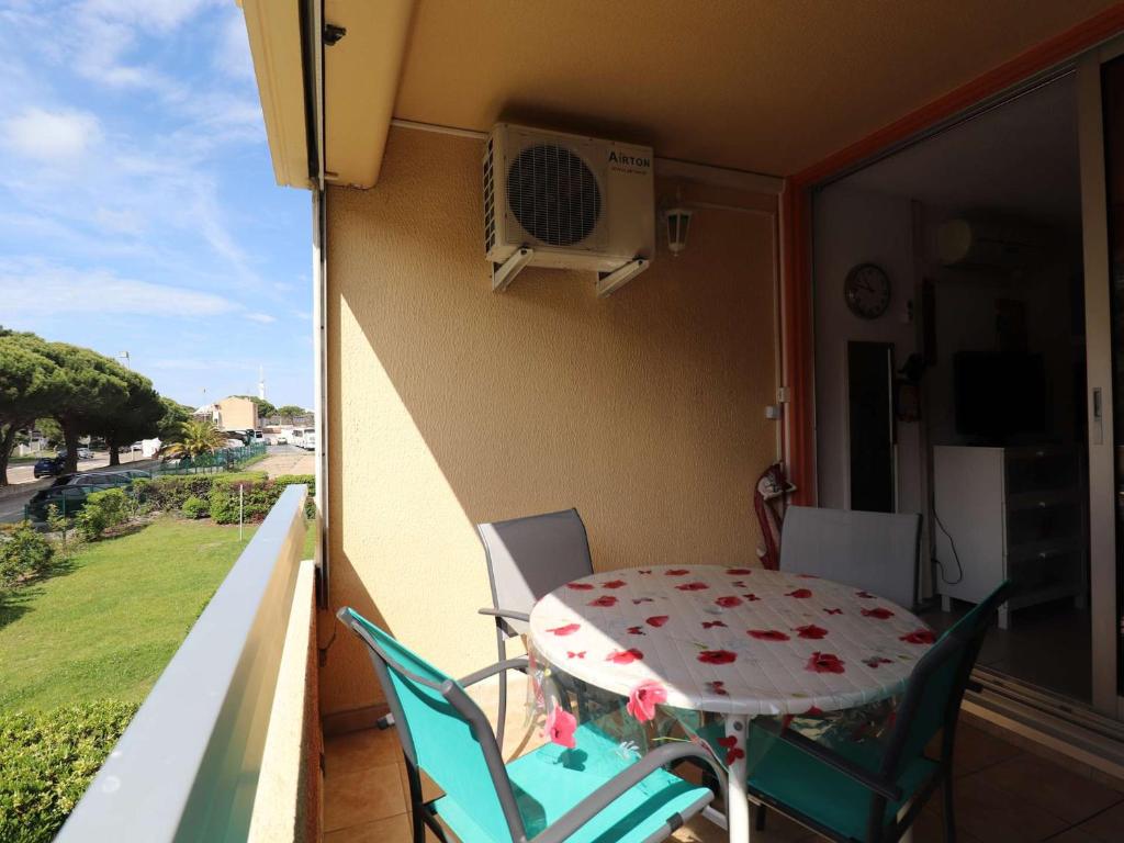 une table et des chaises sur le balcon d'une maison dans l'établissement Studio climatisé avec cabine, terrasse et parking à proximité de la mer - FR-1-307-263, au Grau-du-Roi