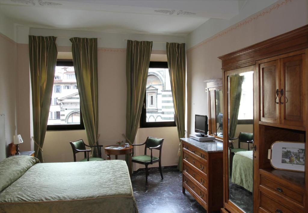 sypialnia z łóżkiem i komodą oraz 2 oknami w obiekcie B&B A Florence View we Florencji