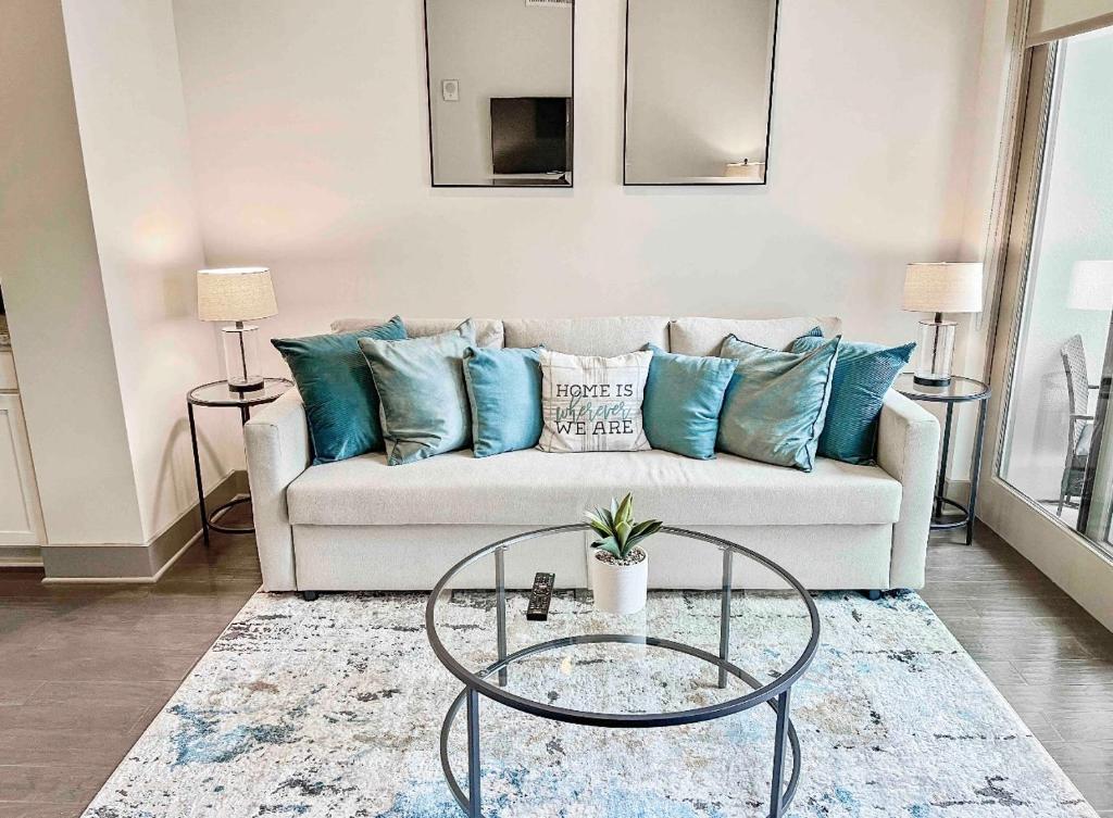 Modern Midtown Oasis في أتلانتا: غرفة معيشة مع أريكة بيضاء مع وسائد زرقاء