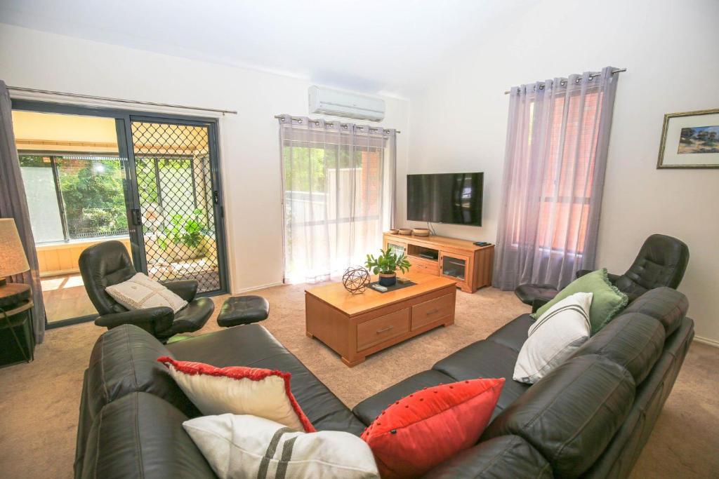 a living room with a couch and a tv at Abenaki in Bright
