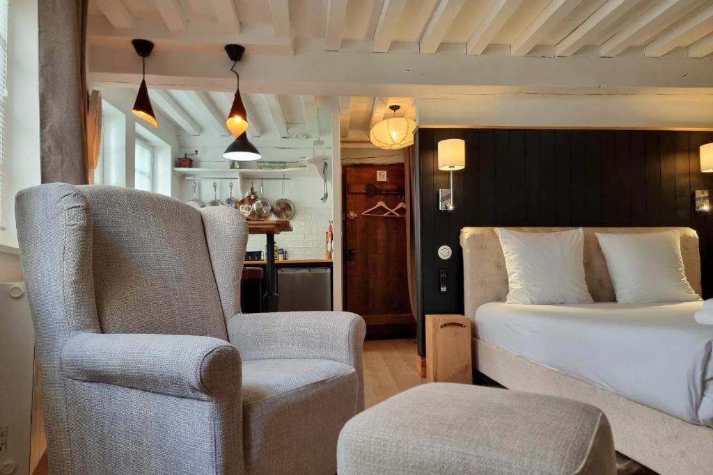 une chambre avec un lit et une chaise dans l'établissement La Parenthèse Saint Jean - studio city center, à Honfleur