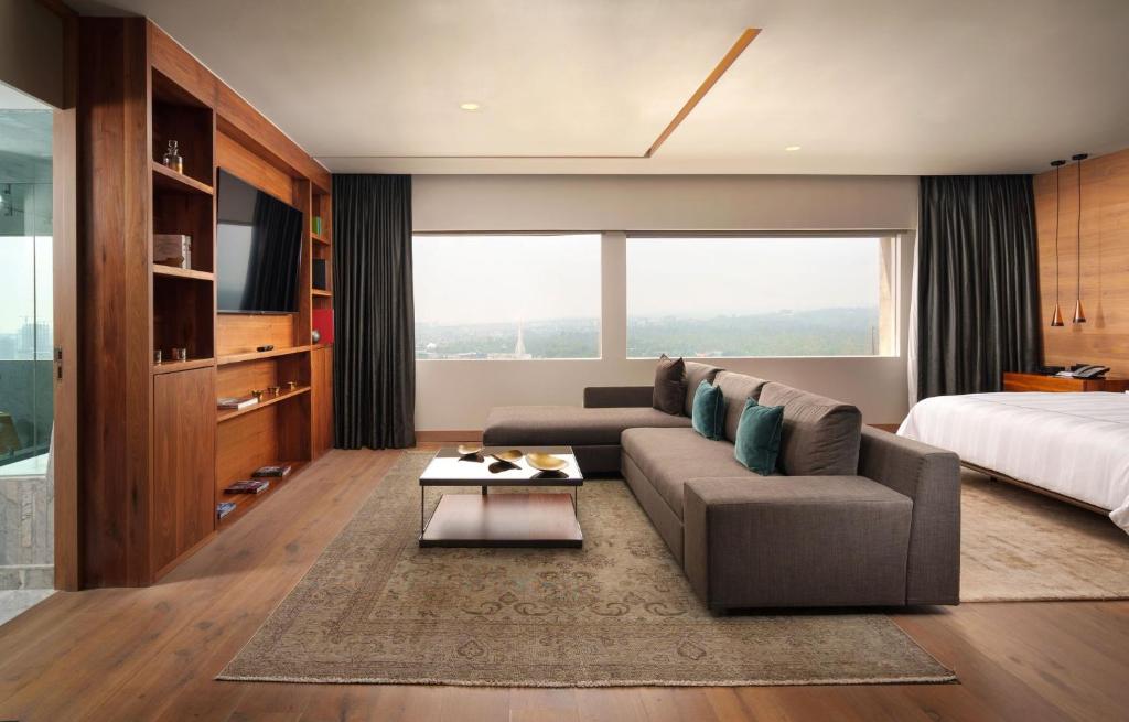 An open suite combining a sitting area, media wall and bedroom.