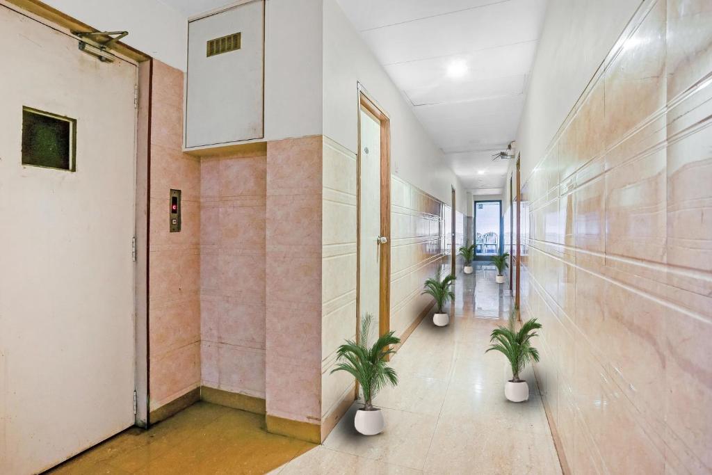 un corridoio con due piante in vaso in un edificio di Hotel Derby a Ulhāsnagar