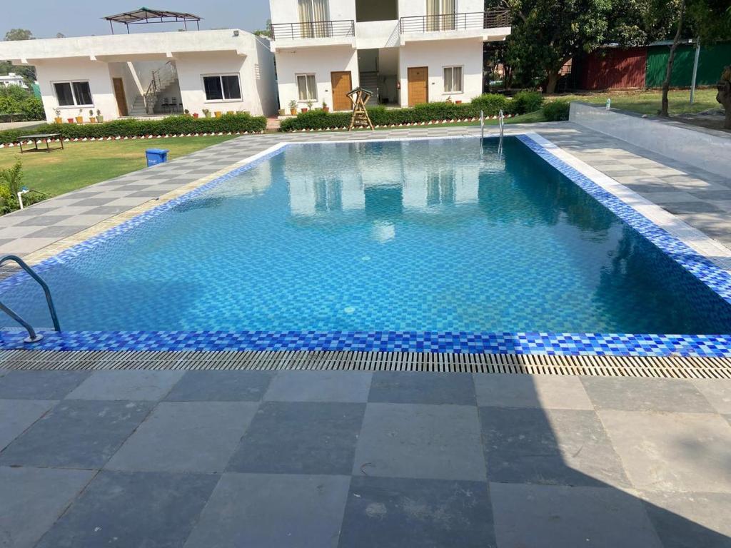 a swimming pool with blue water in front of a building at Great Tiger Resort in Belparāo