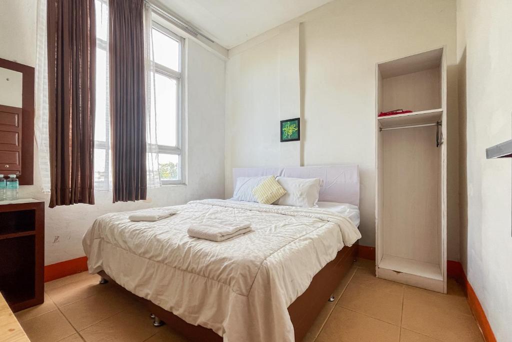 Un dormitorio con una cama con dos toallas encima. en Urbanview Poma Hotel, en Lheue