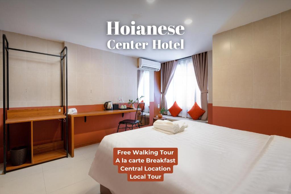 Cette chambre comprend un lit et un bureau. dans l'établissement Hoianese Center Hotel - Truly Hoi An, à Hội An