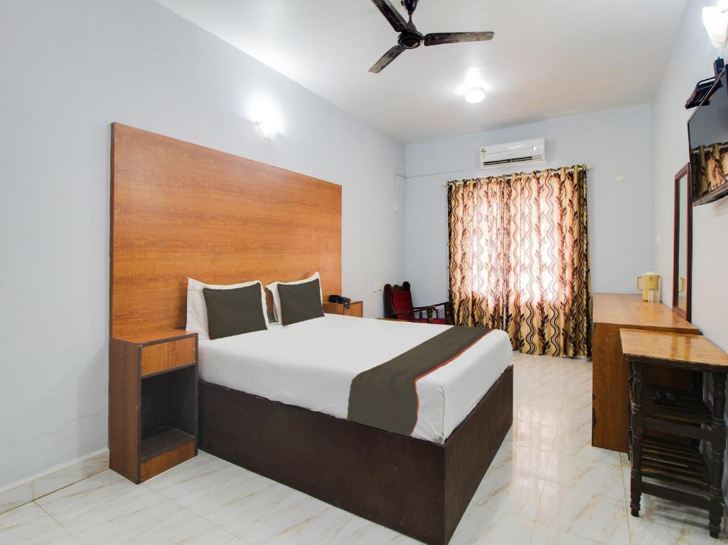 a bedroom with a large bed and a desk at Collection O Maizons Lakeview Resort in Arpora