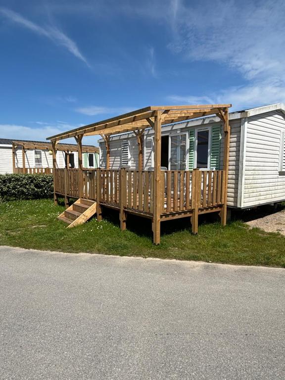 a mobile home with a deck on the grass at CAMPING DU PHARE d OPALE MOBILE HOME J10 in Le Portel